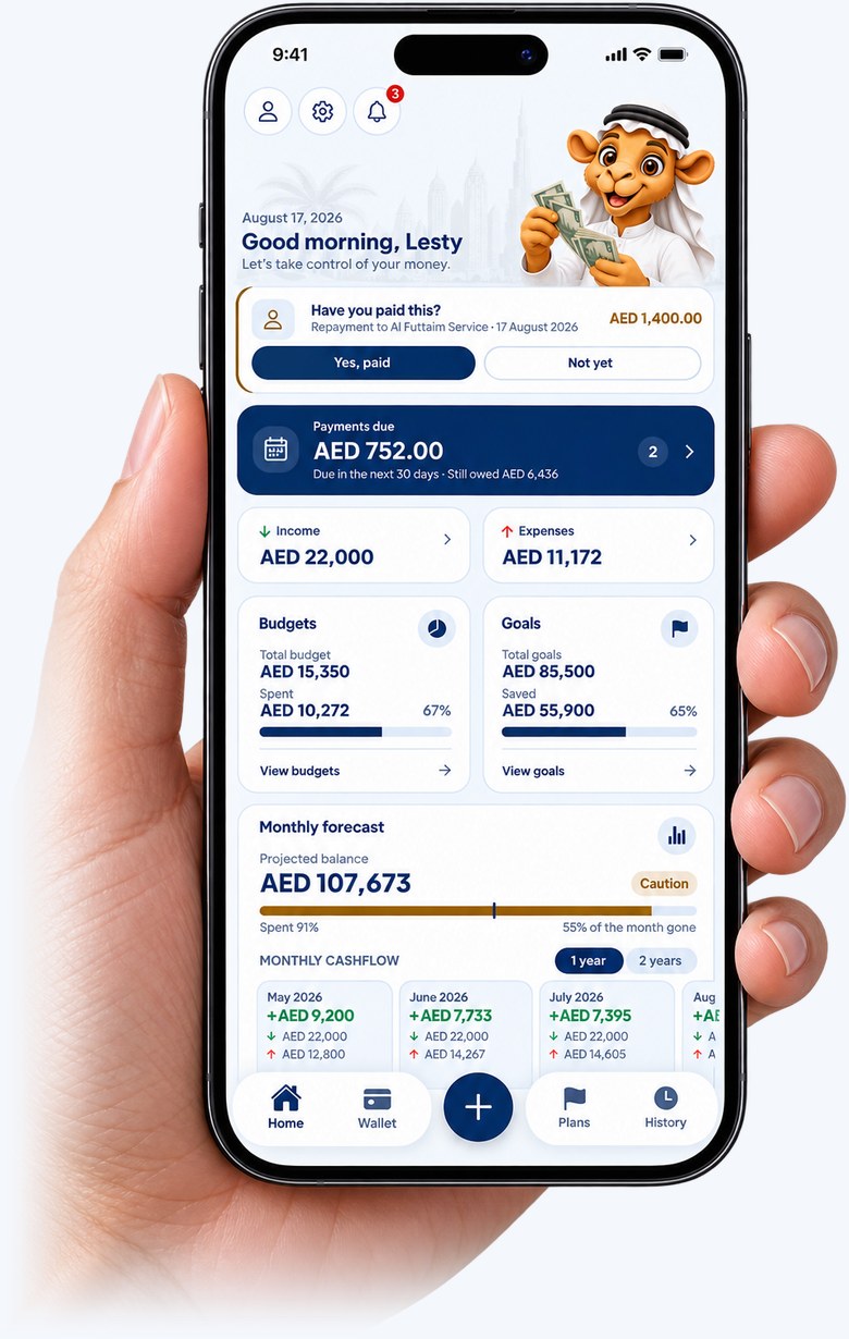 A hand holding a phone showing the Maal home screen: the month's income and expenses, budgets, goals and what is due next.